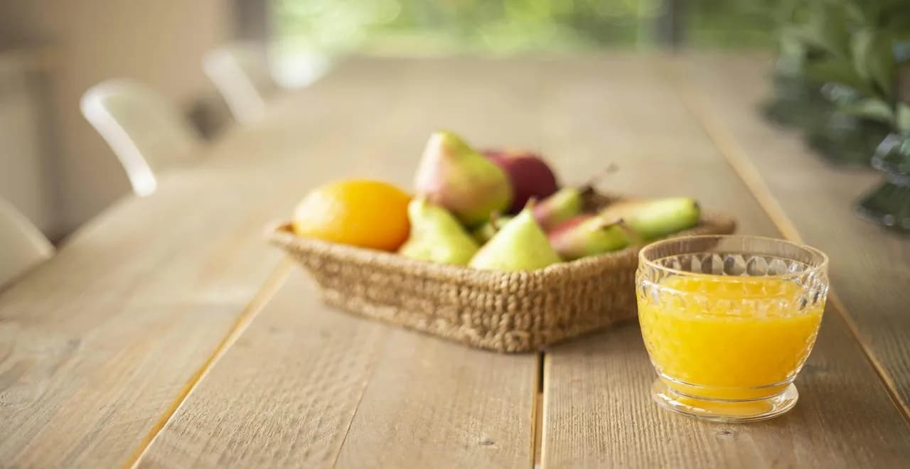 Verre de jus de poire frais avec des poires fraîches en arrière-plan