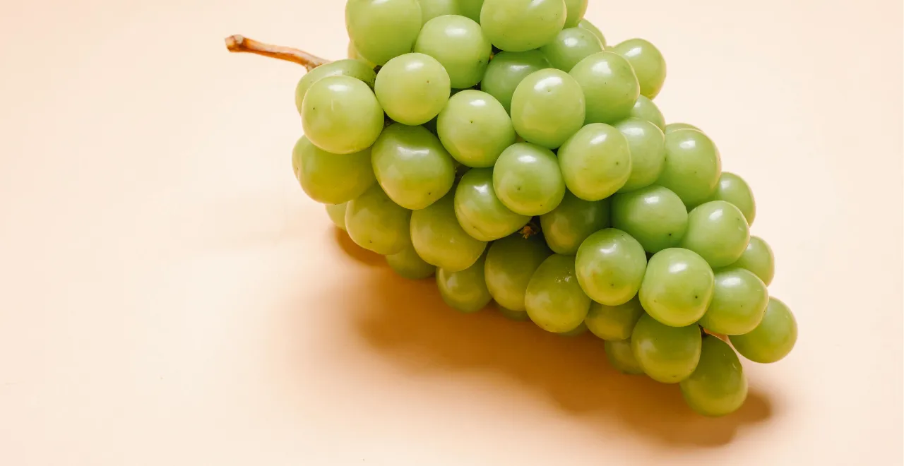 Grappe de raisin à côté d'un verre de jus